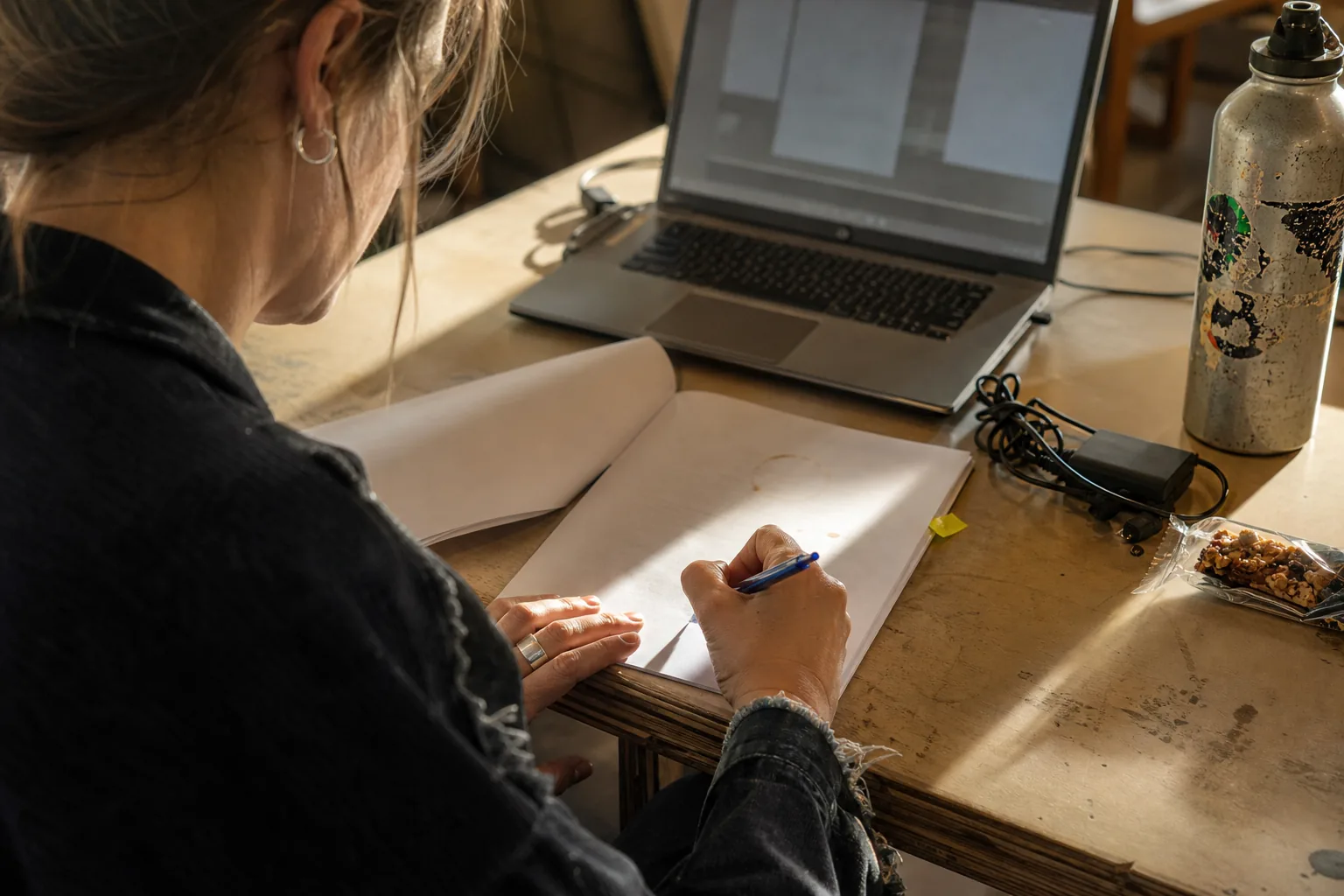 Operations lead initialing the last page of a printed service agreement at a cluttered desk