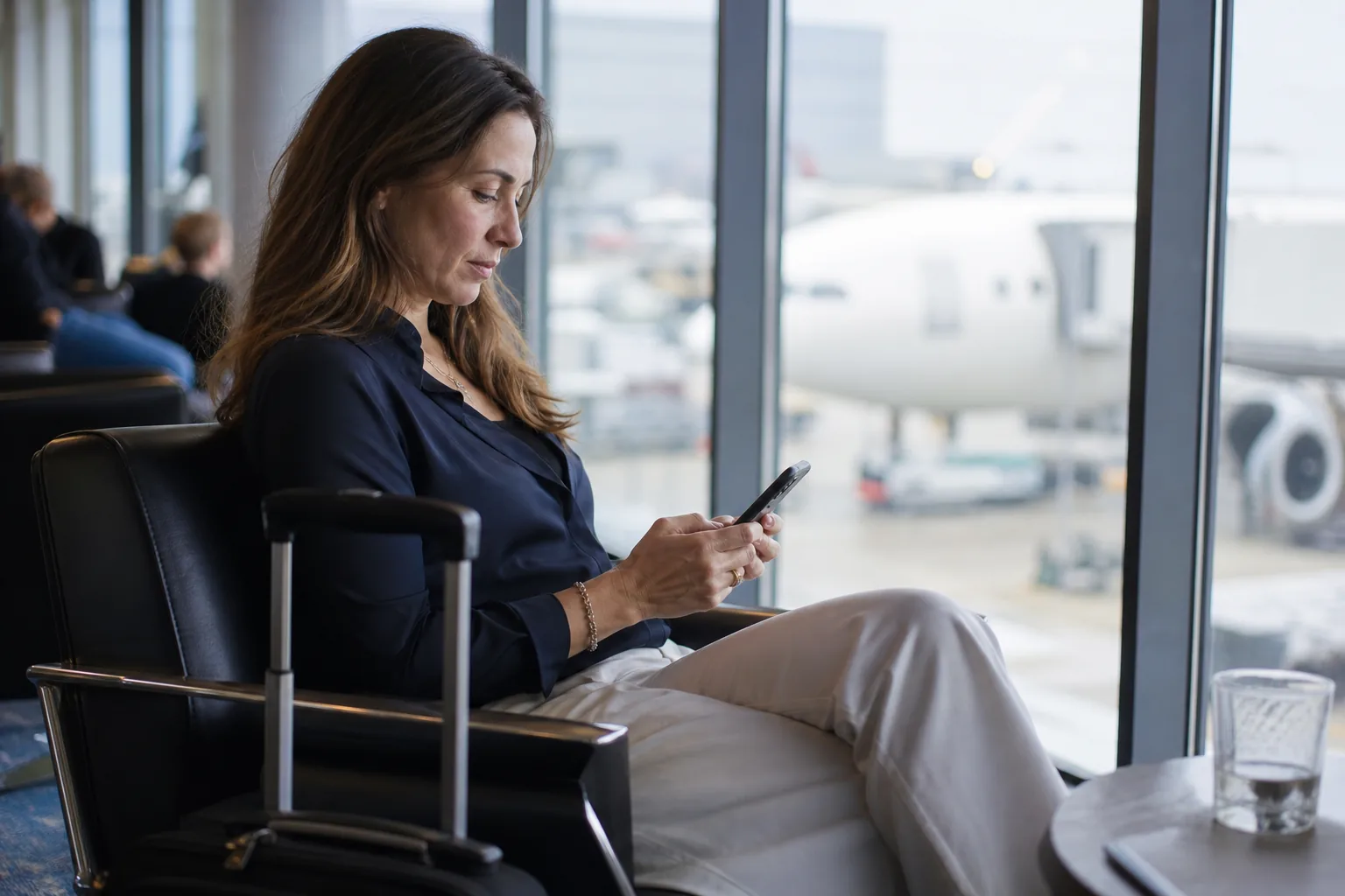Founder signing an agreement on a phone in an airport lounge