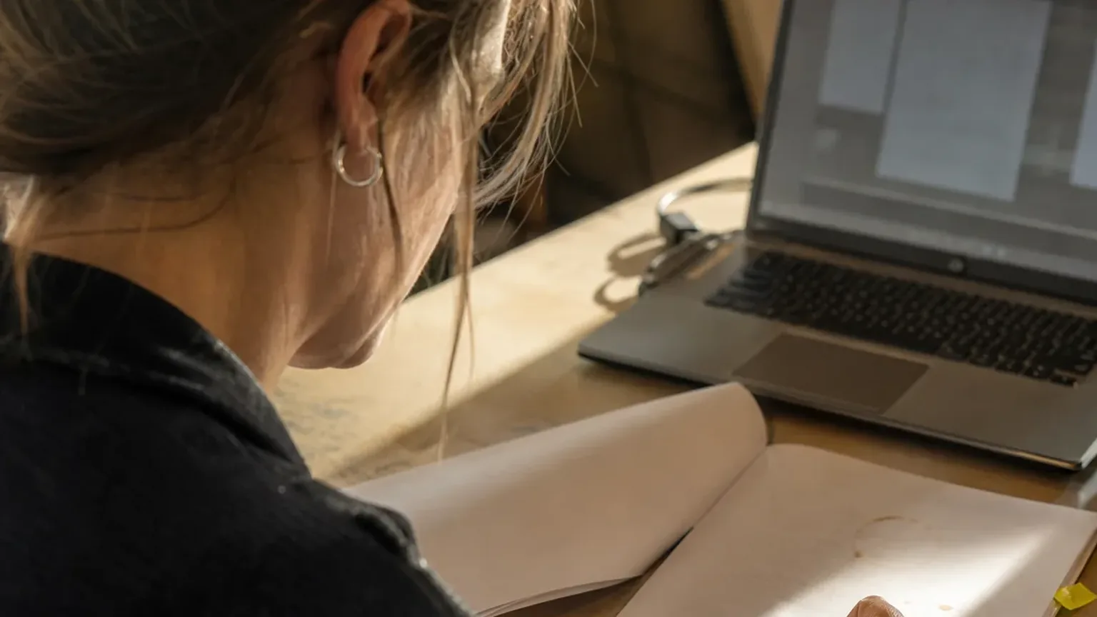 Customer success manager reading a subscription agreement beside her laptop