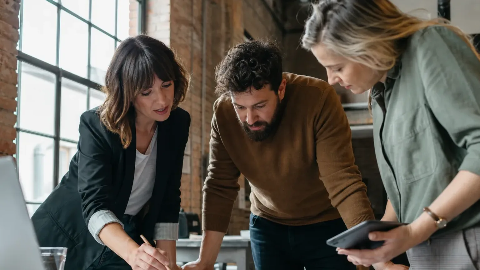 Three colleagues reviewing an agreement draft together before it goes for approval